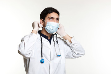 beautiful young doctor in a dressing gown with a stethoscope on a white background in the studio,
