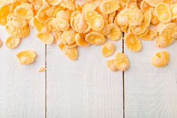 Corn Flakes on white wooden background. Frame. Copy space. Flat lay.