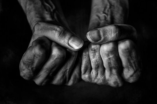 Black and White photo of senior woman fists on black background