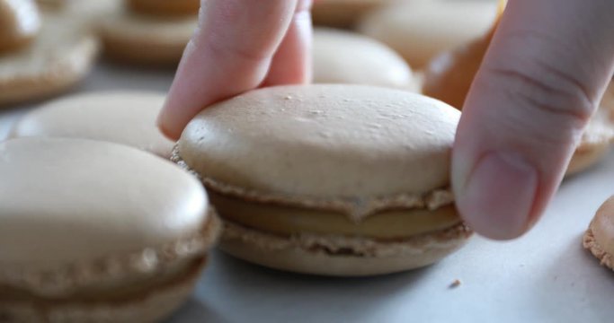Making Caramel Macaroons : Close up shot of connecting two halves of macaroons with caramel cream