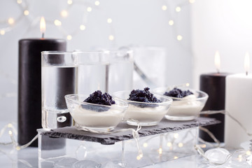 Festive buffet with vodka, black cavier and canddles. Celebration concept for Christmas, new year...