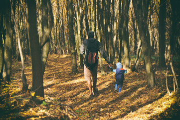 Fototapeta premium Father and son walking in autumn forest with vintage effect