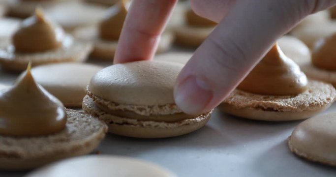 Making Caramel Macaroons : Close up shot of connecting two halves of macaroons with caramel cream