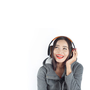 Beautiful asian girl from Thailand listen music from Headphones and sing song on white background