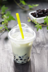 Homemade milk bubble tea in plastic cups on table.