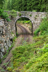 Fototapeta na wymiar Romantic stone bridge over railway in beautiful forest, Czech republic