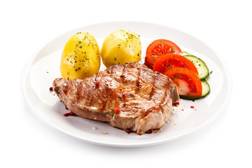 Grilled steak with vegetables on white background
