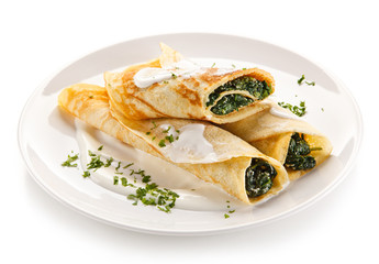 Crepes with spinach and feta cheese on white background