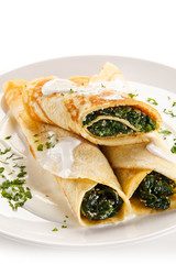 Crepes with spinach and feta cheese on white background