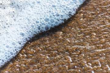 close up of the sea water affecting the sand on the beach, sea waves calmly flowing sand, relaxing...