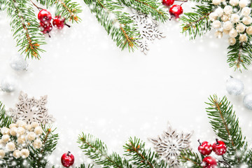 Obraz na płótnie Canvas Christmas background with xmas tree, berries on white wooden background. Merry christmas greeting card, frame, banner. Winter holiday theme. Happy New Year. Flat lay. Snow effect.