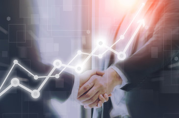 Obraz na płótnie Canvas Businessman making handshake with a businesswoman on futuristic technology connection shape motion blur background with graph and chart rise up.Greeting and dealing business success concepts.