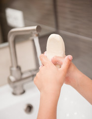 Child is washing his hands with soap