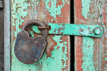 Old rusty vintage lock on a wooden door.