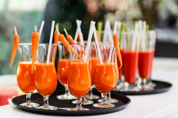Glass of carrot juice decorated with fresh carrots ready to serve in restaurant