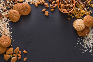 Flat lay oat cookies and nuts on dark background