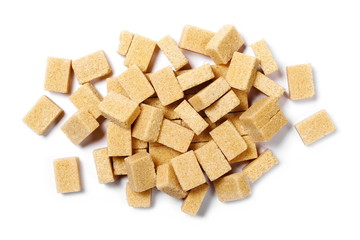 pile brown cane sugar cubes isolated on white background, top view
