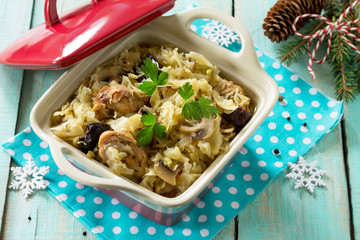 Homemade dinner on a festive Christmas table. Duck stew with cabbage, prunes and mushrooms.