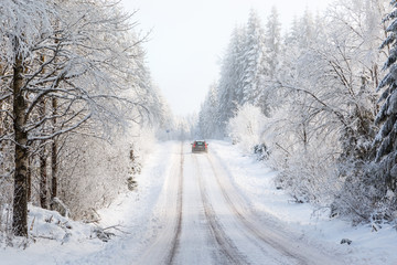 Car driving on a winter road in the woods