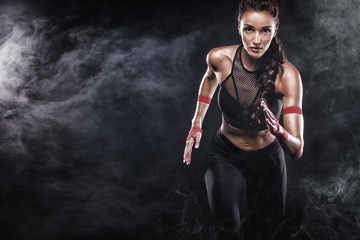 A strong athletic, woman sprinter, running on black background wearing in the sportswear, fitness and sport motivation. Runner concept with copy space. - obrazy, fototapety, plakaty