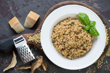 Pasta with ceps and parmesan cheese served in a white plate, view from above