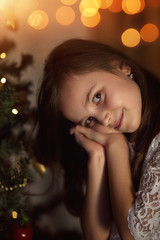 adorable young girl at the Christmas tree on Christmas Eve