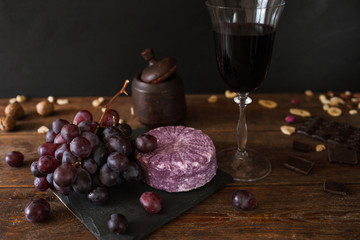 Food composition of dairy gourmet products. Quality sort of cheese with wine and assortment of appetizers, close up