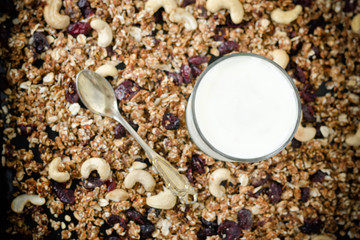 Glass of yogurt, granola on the background. Tea spoon. Food Concept