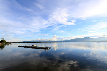 Beautiful sunset and evening sky with mountain and clouds and sunset reflected in the lake for background. Countryside Landscape Under Scenic Colorful Sky At Sunset Dawn Sunrise.