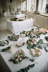 Cake Dessert with macaroons and cakes, decoration green tone on white table