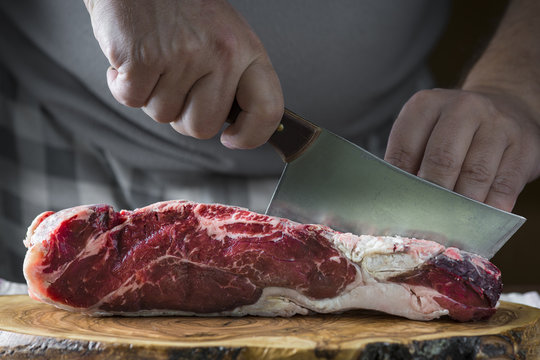Carnicero cortando carne de entrecot de ternera para la comida