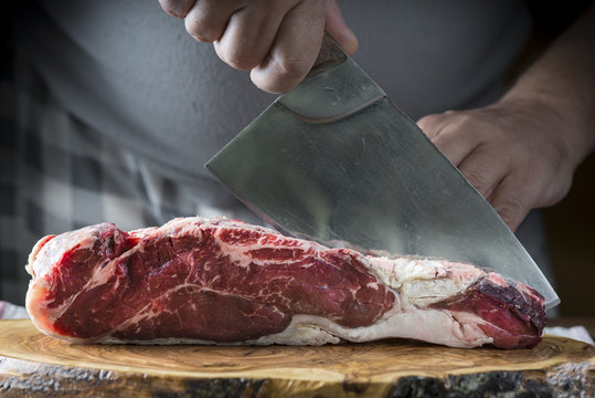 Carnicero cortando carne de entrecot de ternera para la comida