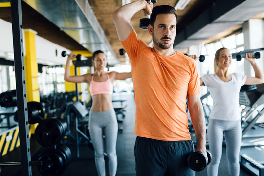 Group of friends exercising together in gym