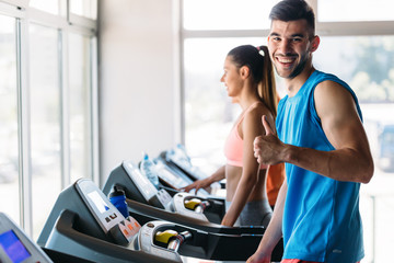 Obraz premium Group of friends exercising on treadmill machine