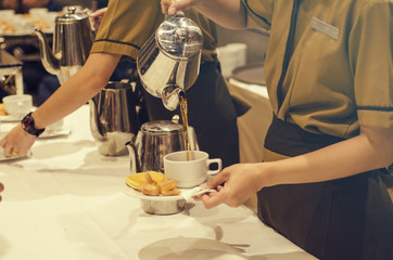 Blurred for Background.The waitress filed a glass of white coffee with the sausage between the brake and the brake food background.