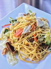 fried noodles with vegetables in white dish .vegan or vegetarian food. Thai cuisine.