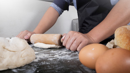 Woman's hands knead dough with flour, eggs and ingredients. at kitchen.