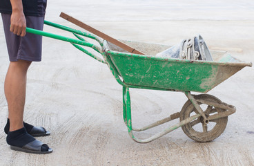 People hand with the soil tralley , cart mortar ,wheel barrow