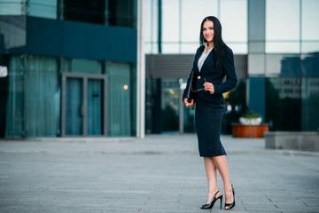 Businesswoman poses against business center
