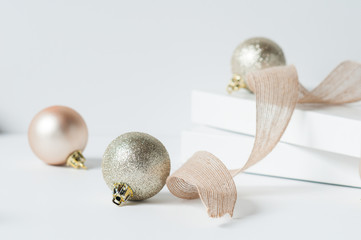 rose gold christmas decorations and ribbion on a white background