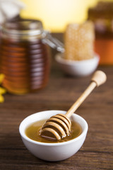 Honey and wooden stick are on a table