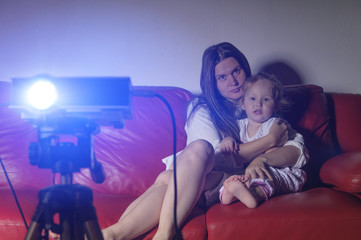 Naklejka premium Watching a movie at home with the projector