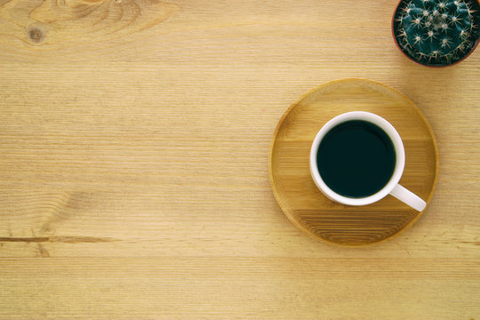 top view image of cup of coffee on wooden table.