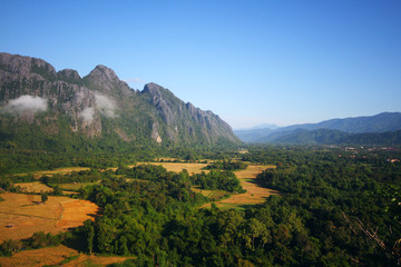 Beautiful mountains scenery in spring.View at a mountain range with morning fog in a mountain valley in Vang vieng, Laos