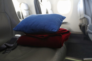 Pillow and blanket lying on the seat in the plane