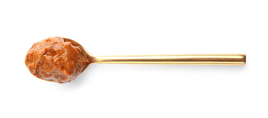 Spoon with delicious caramel sauce on white background