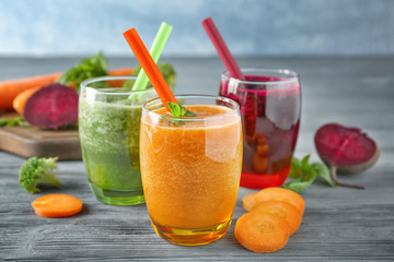 Glasses with different vegetable smoothies on table