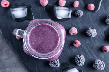 Mason jar with blackberry smoothie on slate plate