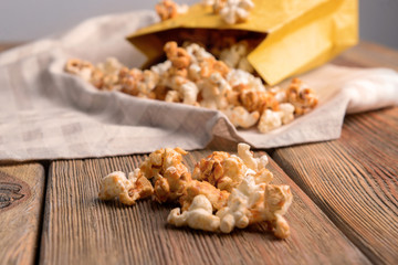 Tasty caramel popcorn on wooden table