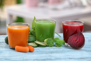 Glasses with various fresh vegetable juices on table